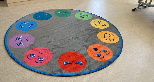 Emotionen Teppich für die GGS im Steinfeld. Auf dem Teppich sind bunte Smileys mit unterschiedlichen Emotionen abgebildet.